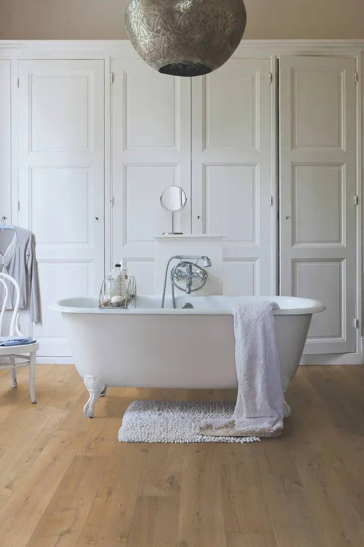 Natural oak laminate flooring in a bathroom with a freestanding bath, Camberwell Floorworld